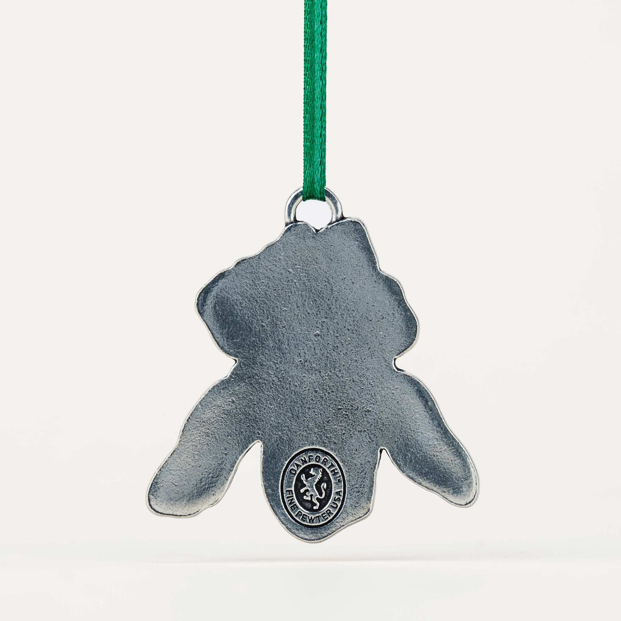 back of the iris-shaped ornament with a green string on a white background