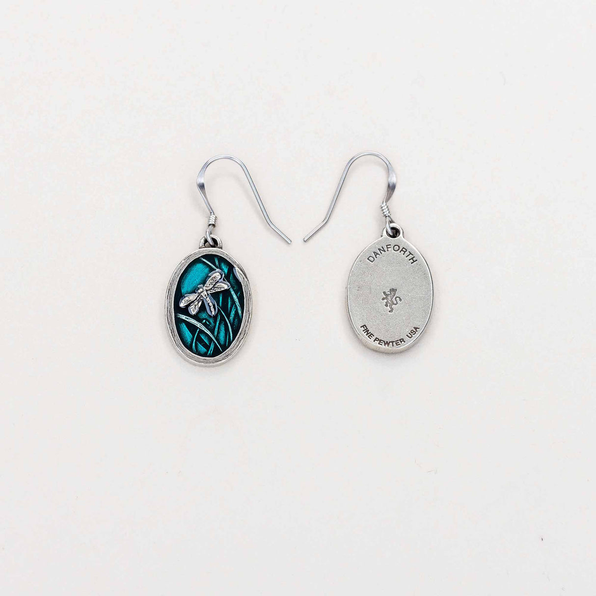 A pair of dragonfly earrings, with one flipped over to reveal the reverse side and the maker’s mark, highlighting fine craftsmanship.