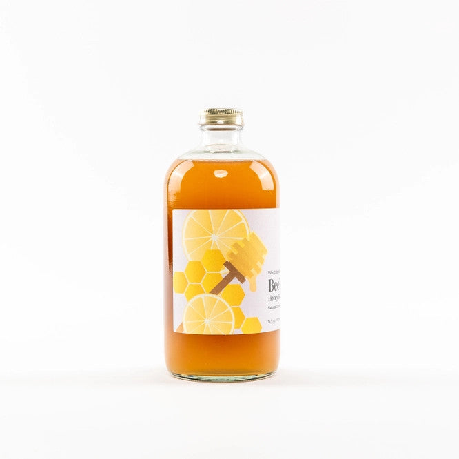 side view of Bee's Knees Mixer bottle featuring honeycomb design on label