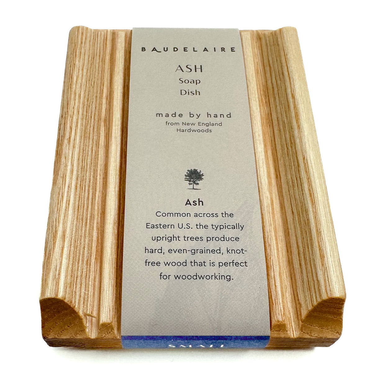 The Ash Soap Dish shown with its paper wrap packaging which highlights that it is made by hand from New England Hardwoods and made of Ash