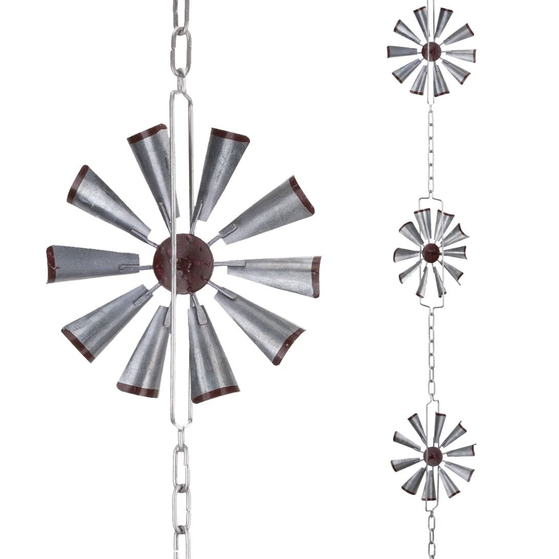 Decorative metal windmill hanging from chains on a white background