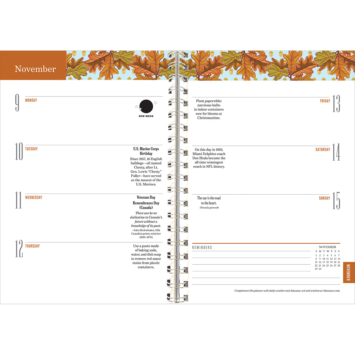 Interior page of the Old Farmer's Almanac planner showing the November 9-15 weekly planner page spread noting moon phases, holidays, with autumnal orange and yellow oak leaves illustration at the top of the pages