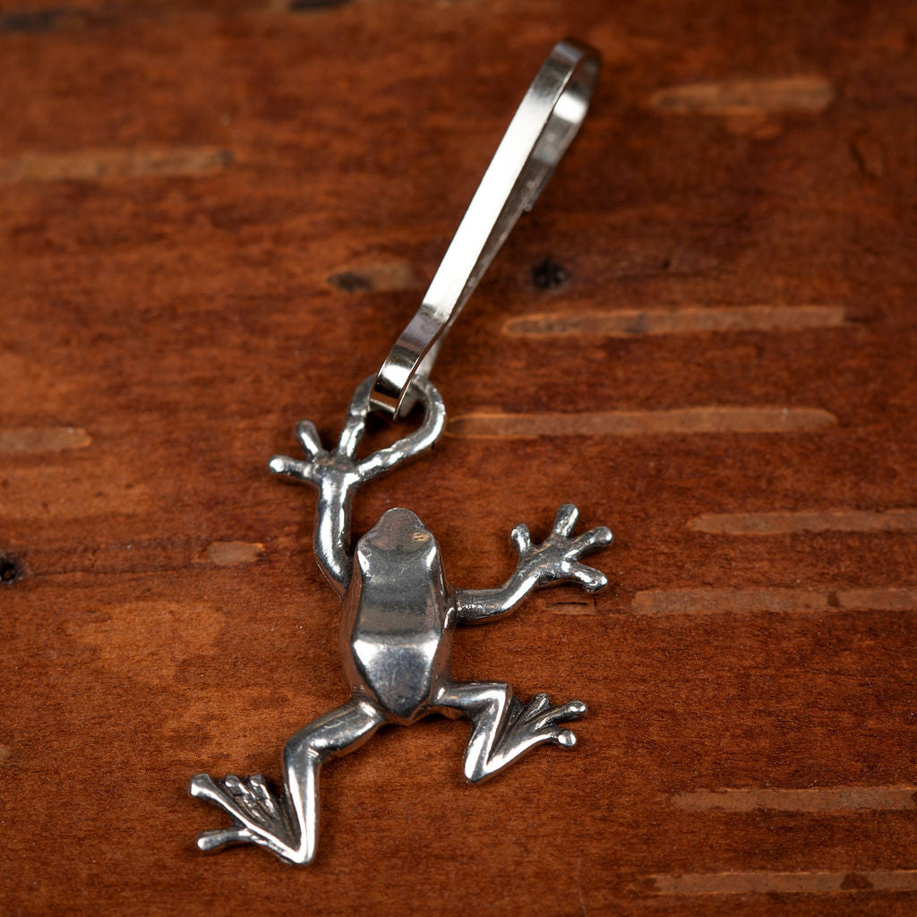 the tree frog zipper pull laid on natural wood surface