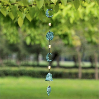 a wide view of the sun and moon wind chime hanging from a tree outdoors