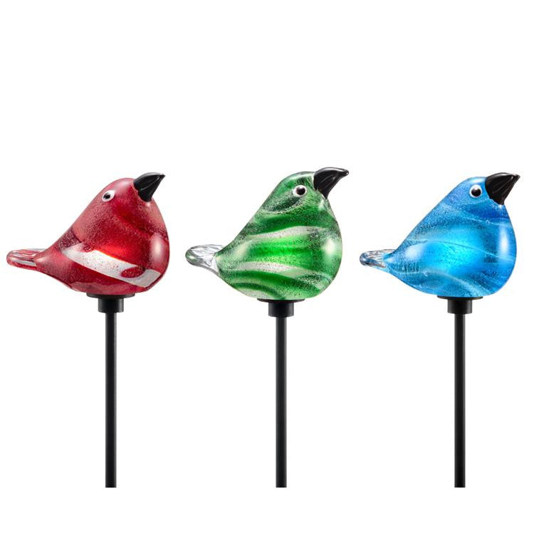 close up view of the 3 glass bird stakes in a row: red, green, and blue shown from left to right against a white background