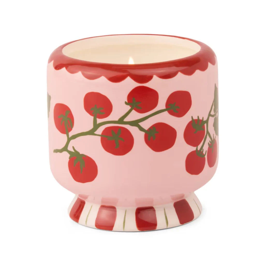 Ceramic candle vessel with red tomato design on a white background
