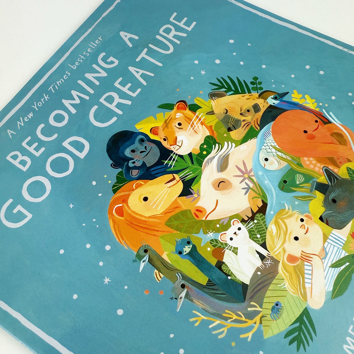 Book cover of 'Becoming a Good Creature' with illustrated animals on a blue background