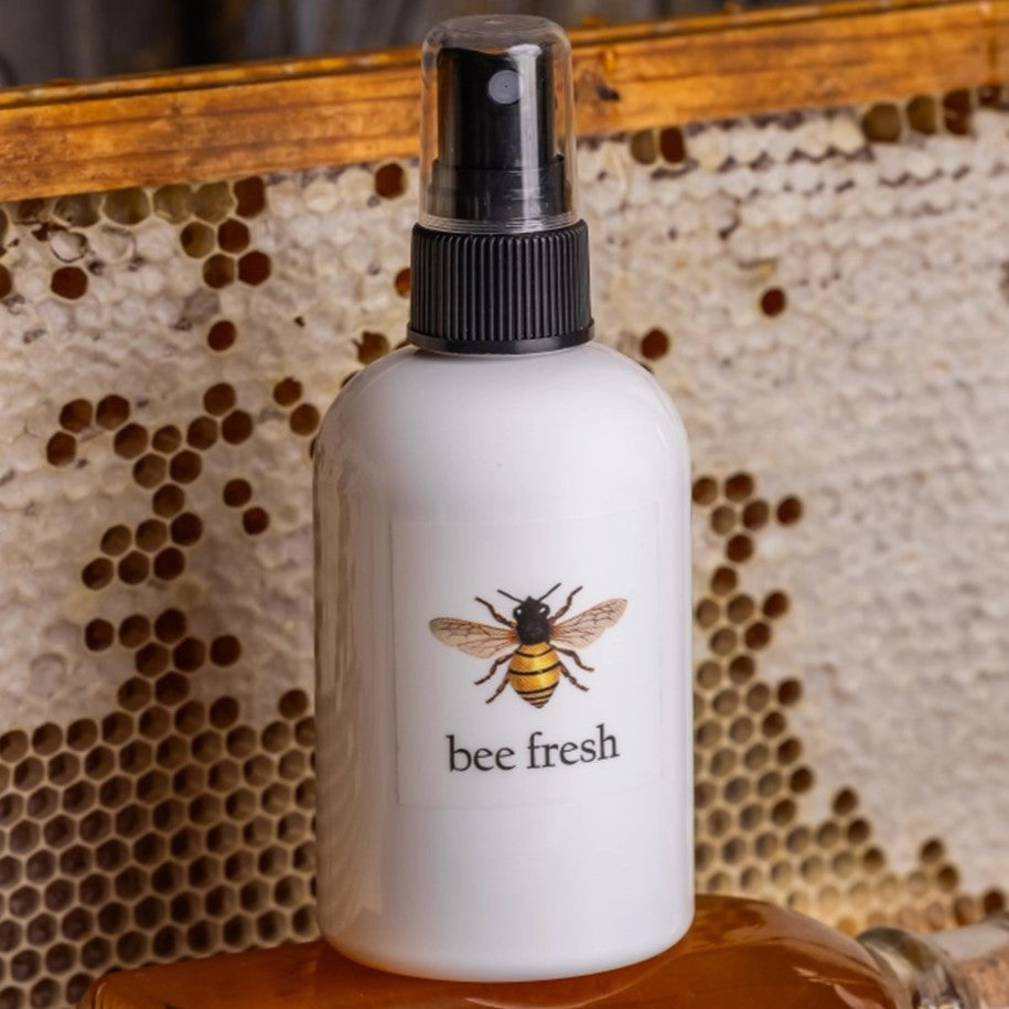 the Bee Fresh toner spray bottle; a white bottle with an illustration of a honey bee and text that reads "bee Fresh" with a black sprayer at the top of the bottle