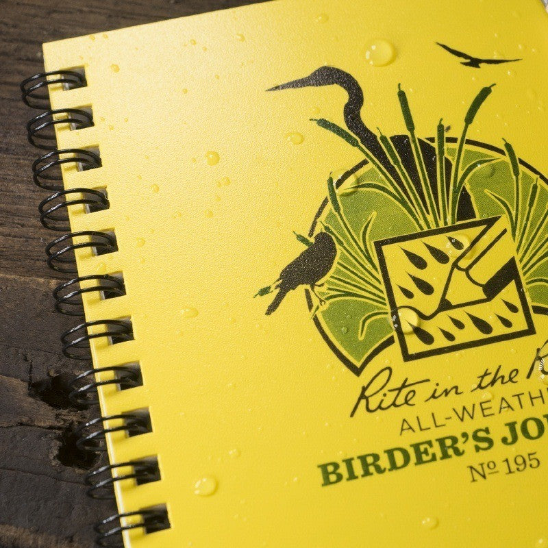 a close up of the birder's journal with yellow cover and black spiral binding