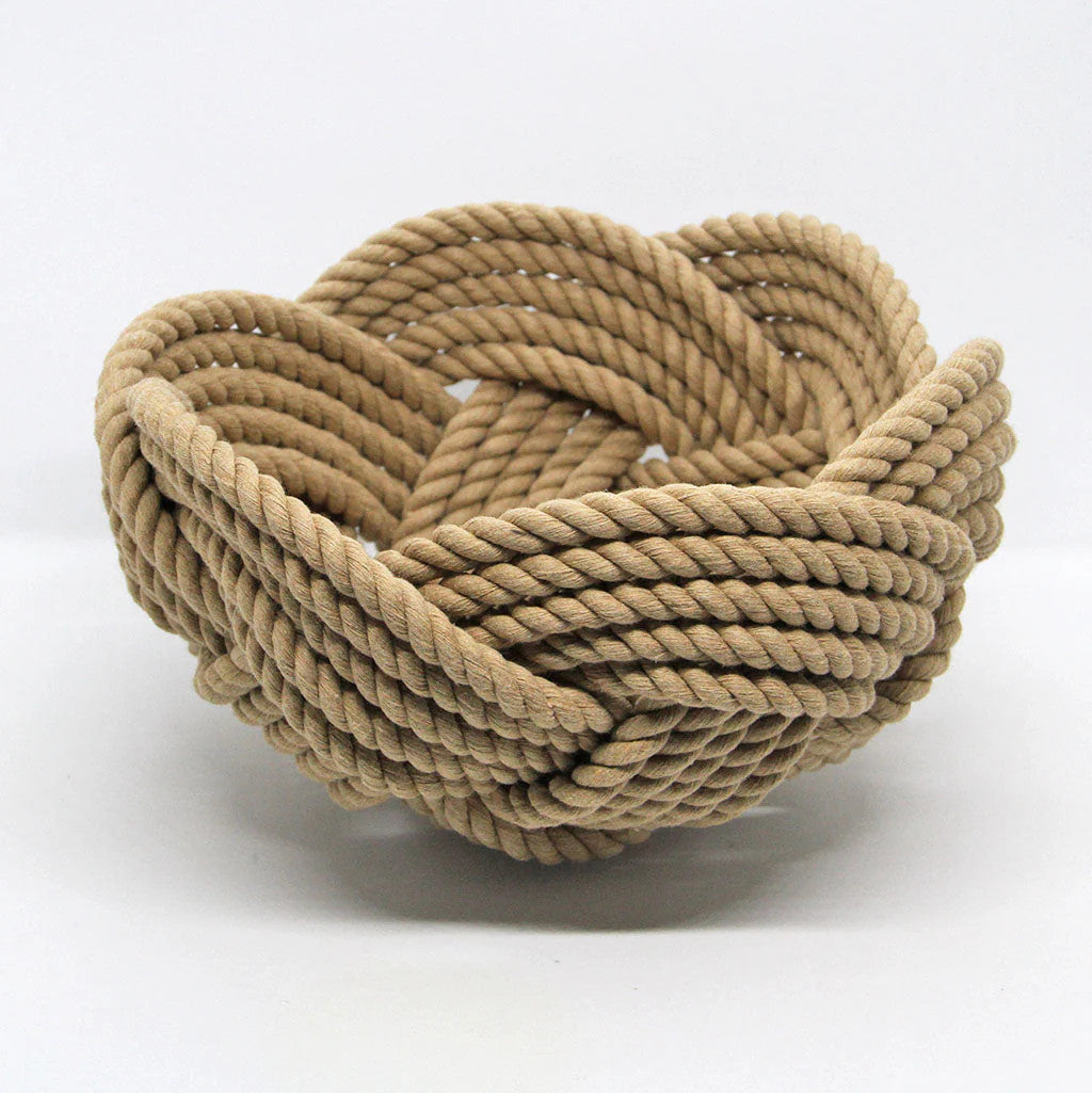 a hand woven cotton rope bowl in tan against a white background
