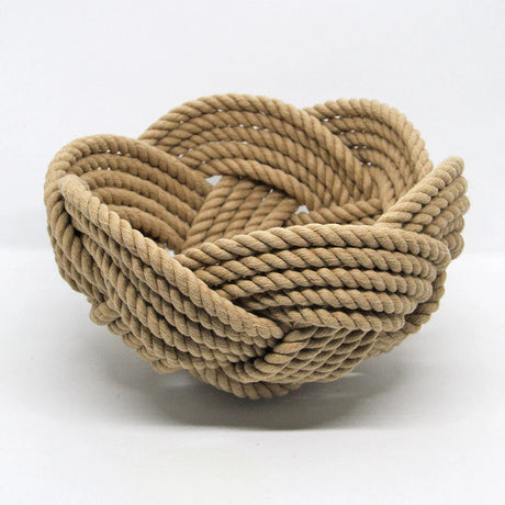 a hand woven cotton rope bowl in tan against a white background