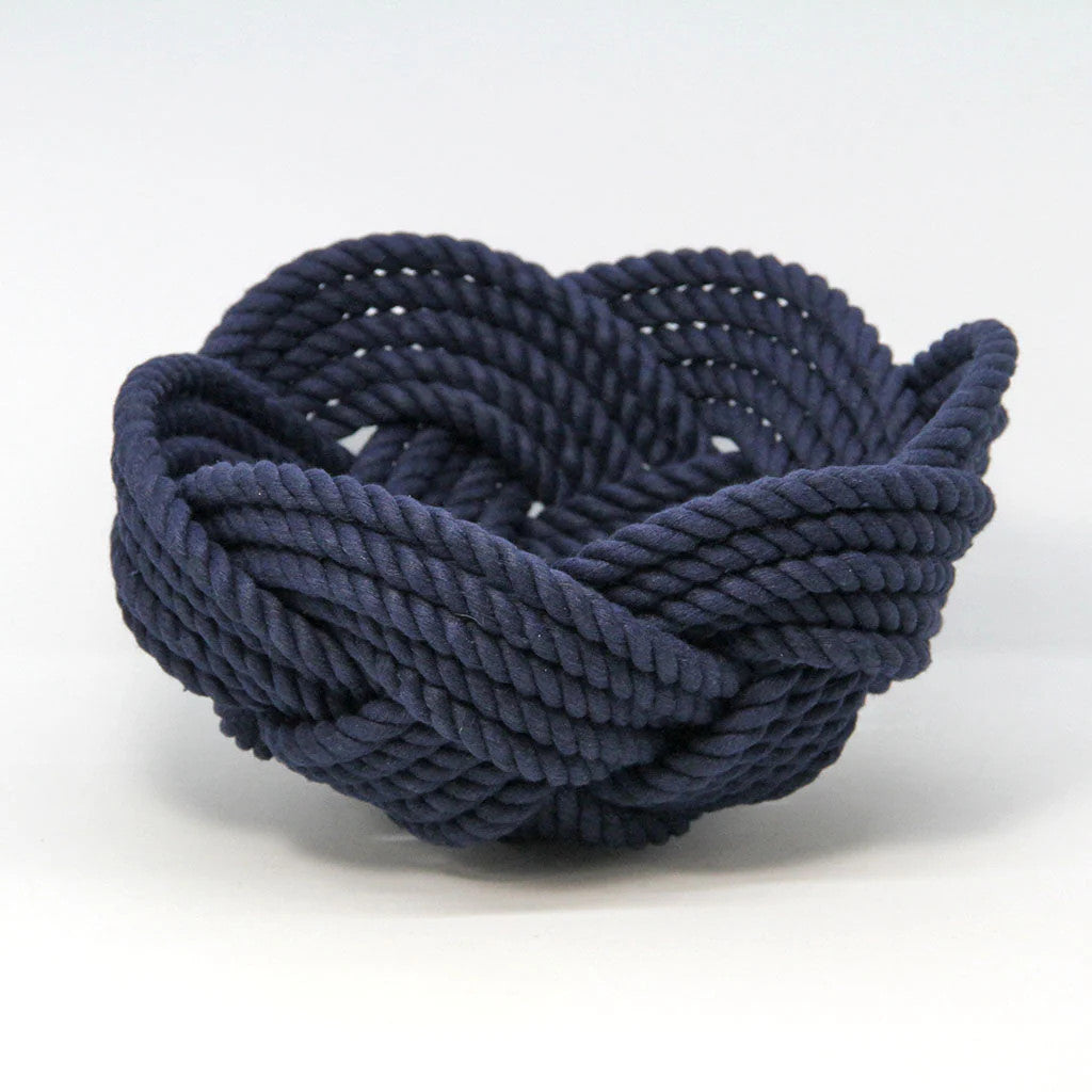 a hand woven cotton rope bowl in navy blue against a white background