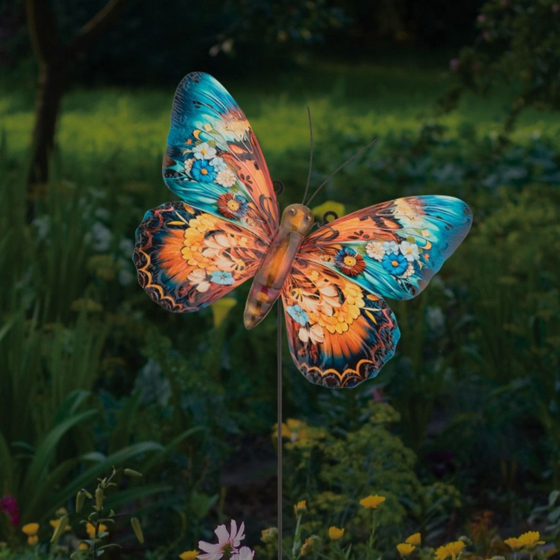 the butterfly decor as a stake installed in a lush green garden
