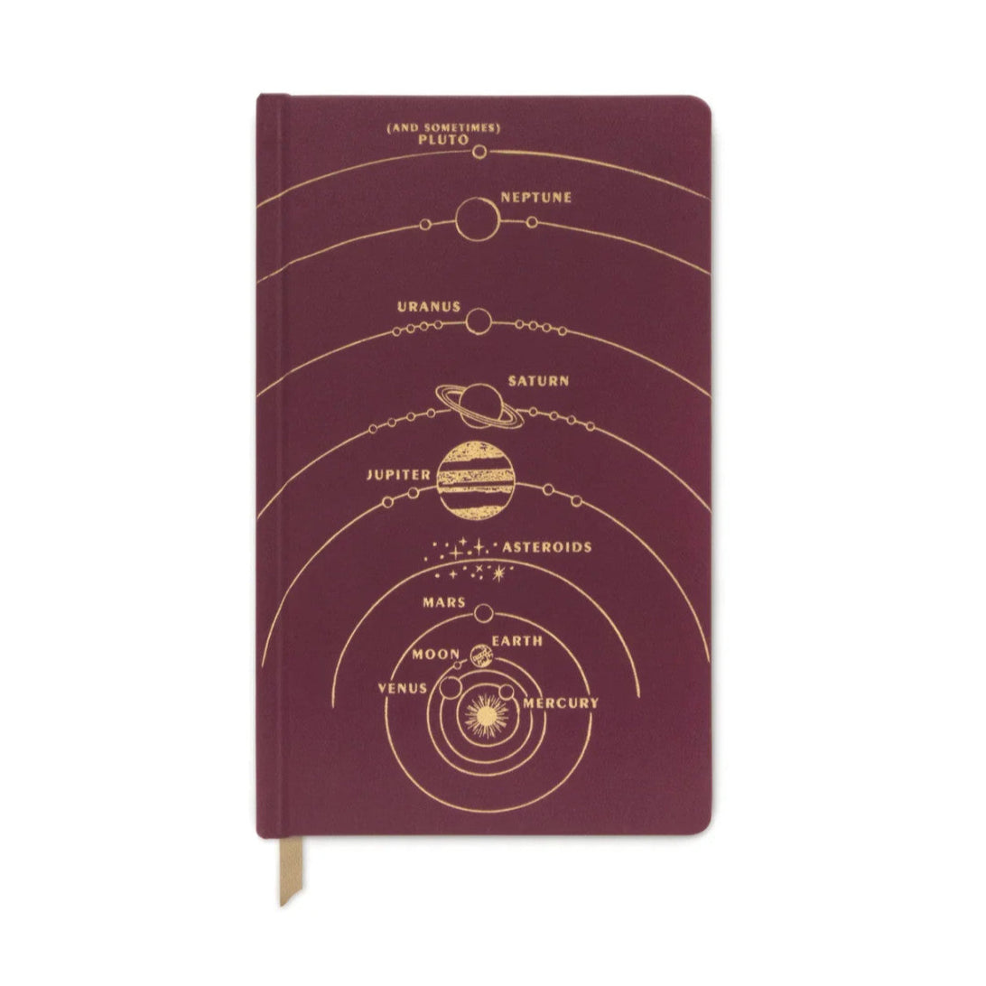 a rich burgundy hardcover journal adorned with an intricate gold foil design of the Solar System, spanning the entire cover from top to bottom. At the base, a radiant sun is surrounded by Mercury, Venus, Earth, and Mars, with elegant orbit bands stretching to include all the planets