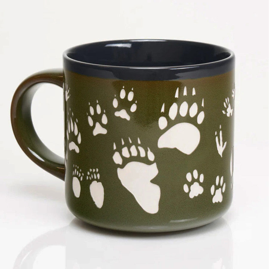 a deep green coffee mug with various animal tracks in white including paw prints, hoof prints, birds, and more