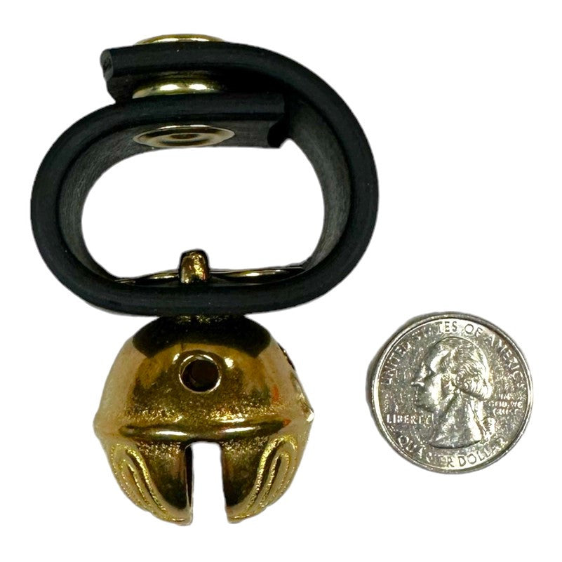 brass bell on a black leather loop with a snap closure next to a quarter to give an idea for scale - the bell is a bit larger than the quarter