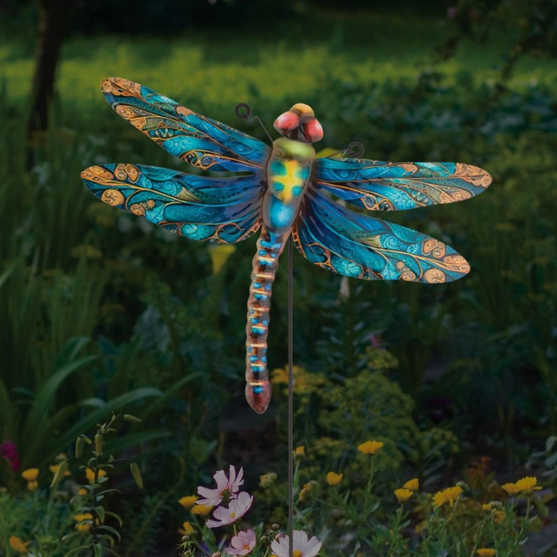 the dragonfly decor as a stake installed in a lush green garden