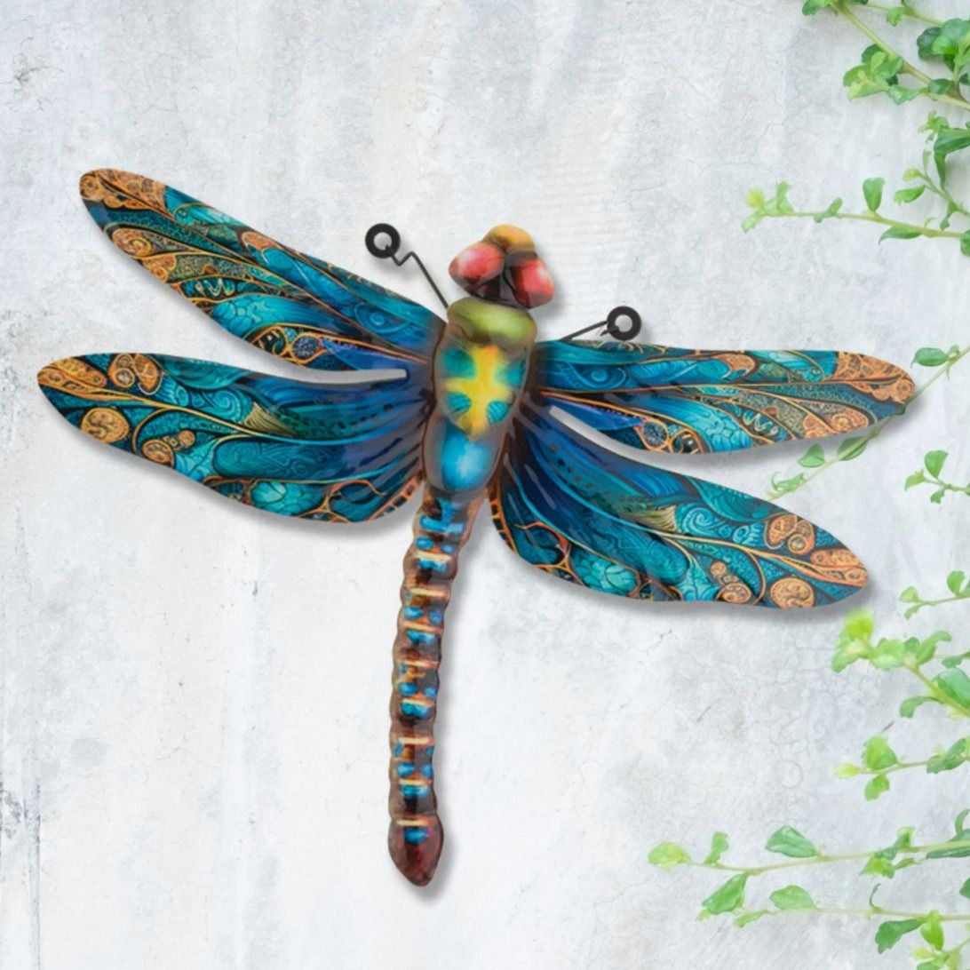 the dragonfly decor installed on a white and gray wall with green vines