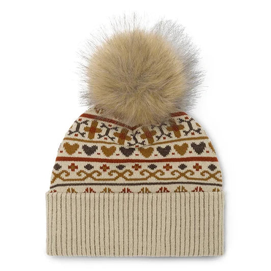 A knit beanie hat with a large fluffy faux-fur pom-pom on top. The beanie has a cream ribbed cuff and a patterned upper section featuring geometric and heart motifs in brown, rust red, and dark brown on a cream background.