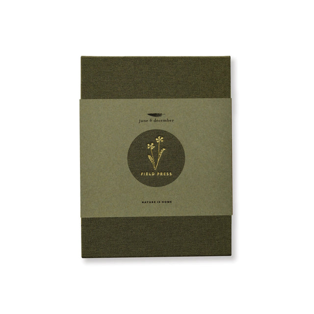 the field press with green linen cover and gold foil floral detail, comes in a hemp paper wrap