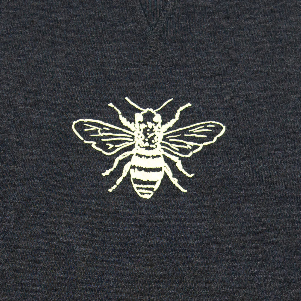 White printed bee design on a dark fabric background