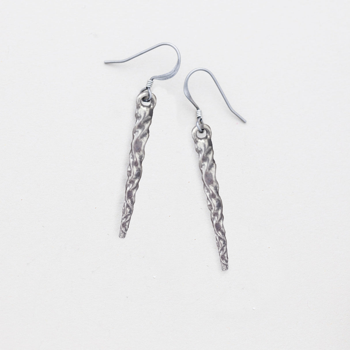 pewter icicle earrings laying flat on a white background