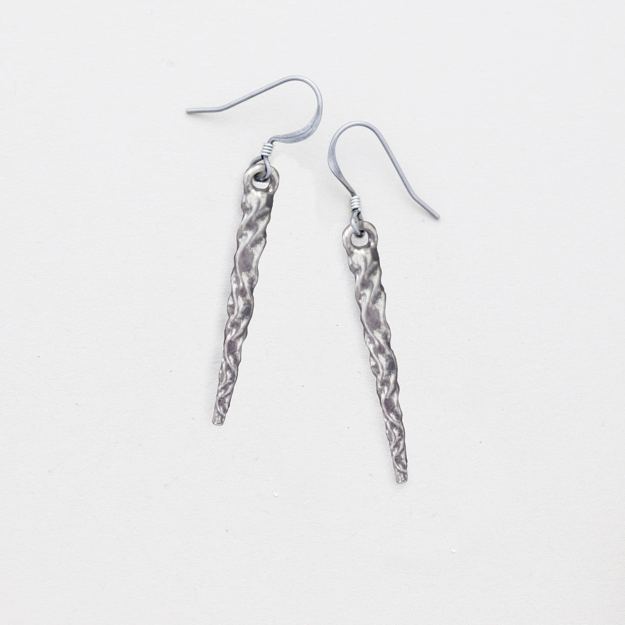 pewter icicle earrings laying flat on a white background