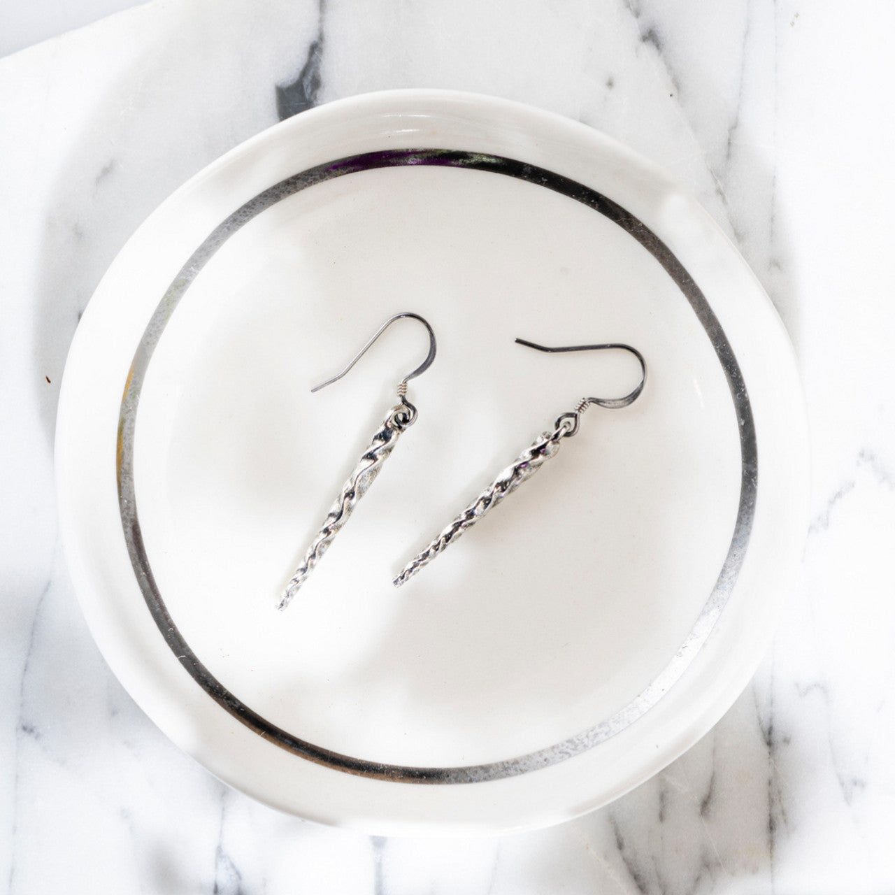 pewter icicle earrings in a white and silver catchall dish