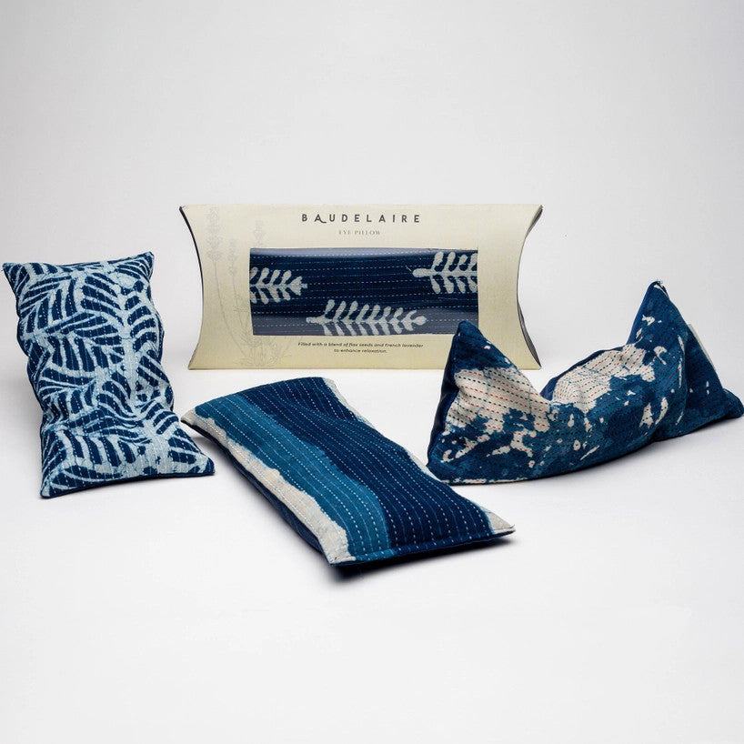 a spread of 3 of the indigo eye pillows out of their packaging, and one within its packaging