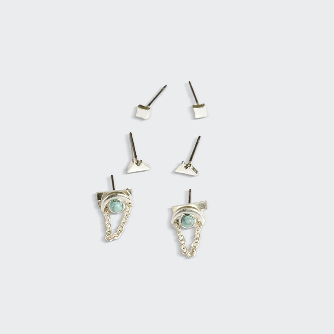 Set of silver earrings with gemstones on a light gray background