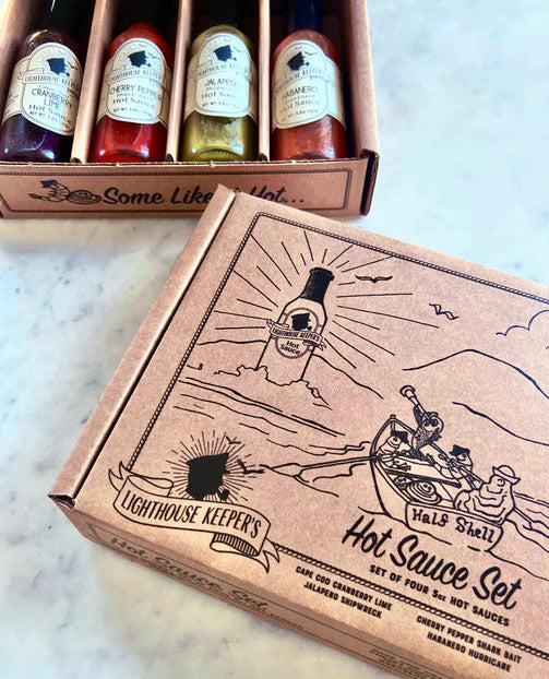 a marble countertop with the hot sauce gift set box alongside an open gift box showing the hot sauce bottles