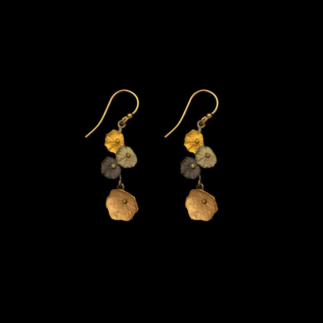 a pair of earrings modeled after nasturtiums with four layered blooms cast in bronze and adorned with mixed metal finishes against a black background