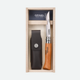 a carbon steel folding knife and sheath shown in its wooden gift box with Opinel branding