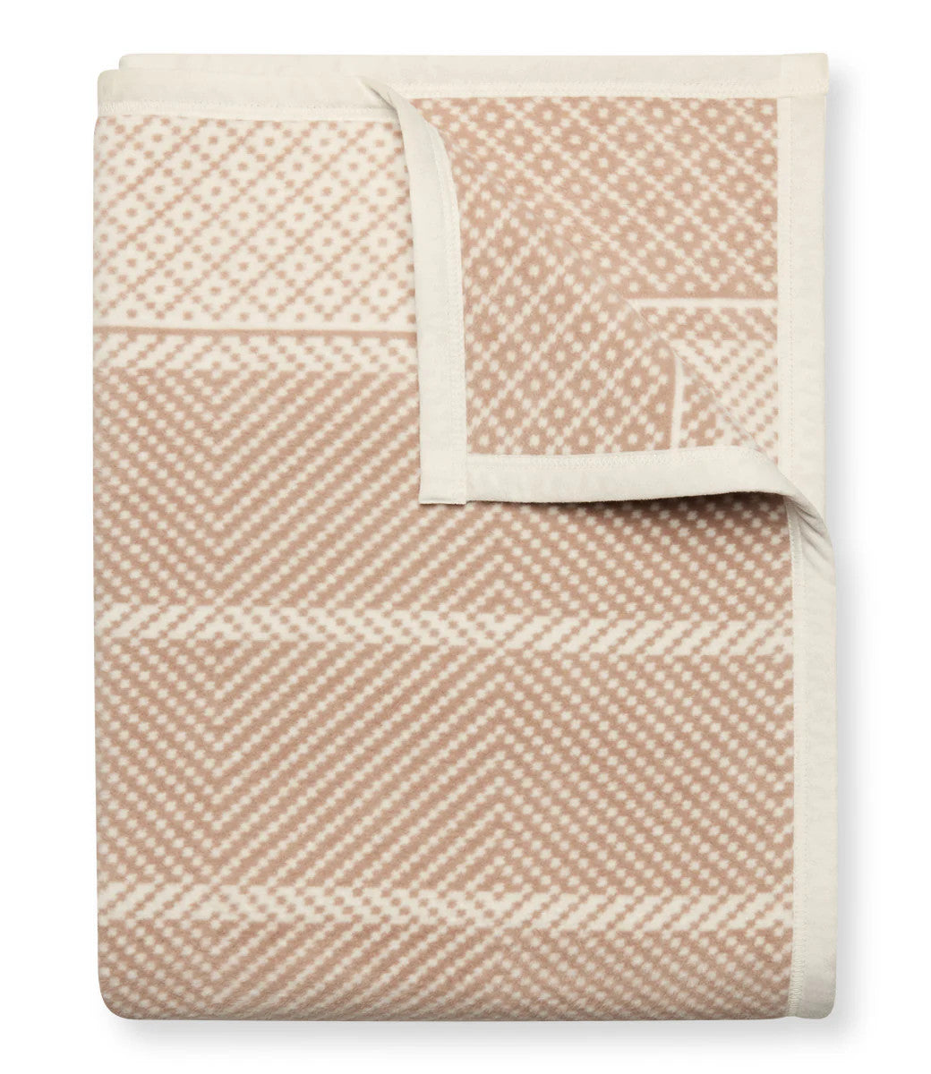 A folded Old Port Herringbone Tan blanket with the top right corner folded over to show the reverse of the design