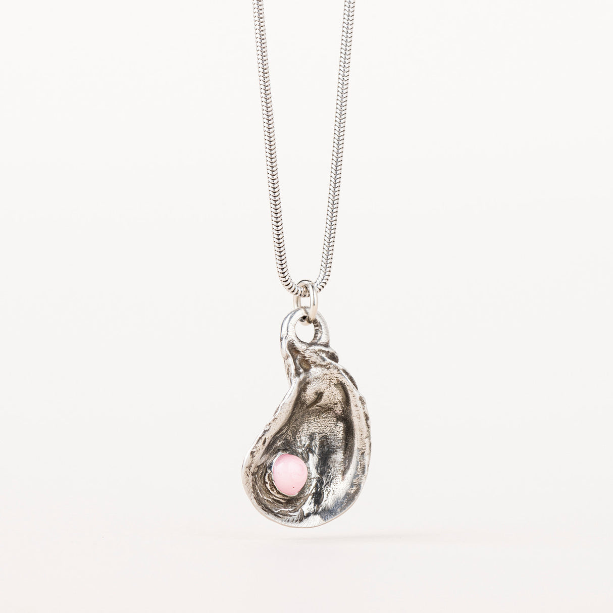 Silver Oyster Shell Necklace with a pendant molded from a real oyster shell, featuring delicate pink pearl-like decorations. The pendant hangs on a 29-inch chain