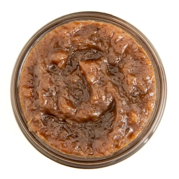 Close-up of a jar of savory caramelized onion jam on a white background