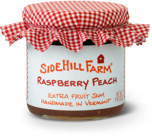 Jar of Sidehill Farm Raspberry Peach jam with a red and white checkered lid on a white background