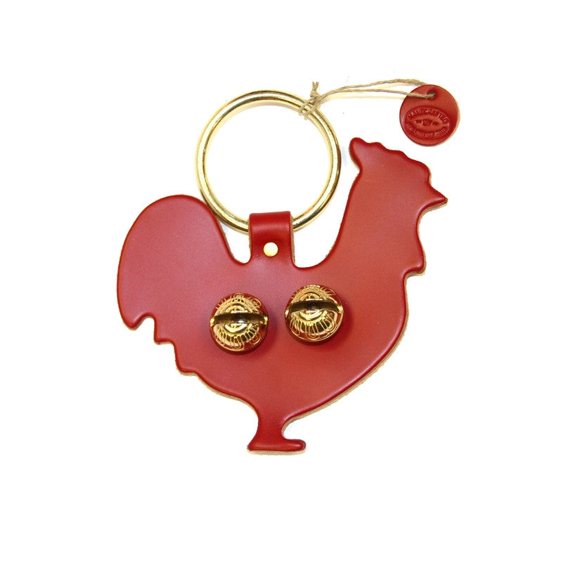 a door hanger bell in red leather stamped in the shape of a rooster in profile - includes 2 brass bells in the body and a brass loop for hanging on a door