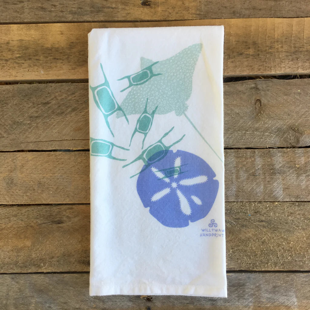 Folded towel with sand dollar design on a wooden surface