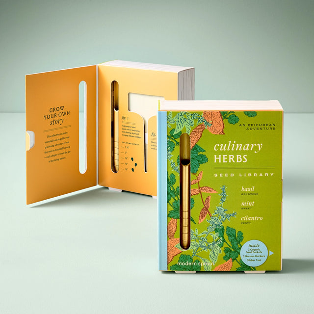 Seed library packaging with a pen and open book on a light gray background