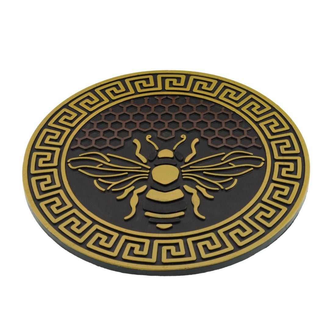 garden stepping stone with bee design and honeycomb background in yellow and brown shown at a slight angle