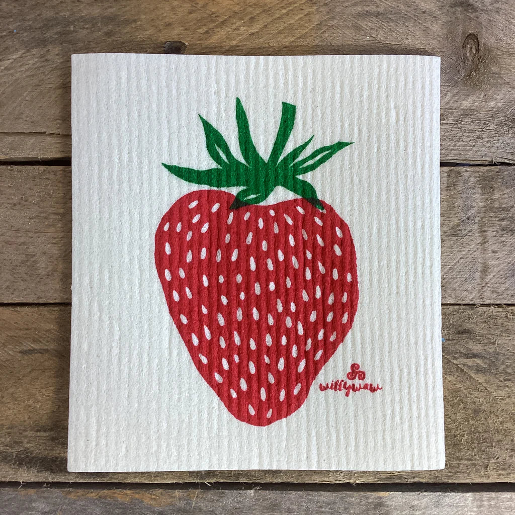 a white, rectangular dish cloth with a large hand printed strawberry illustration in red and green