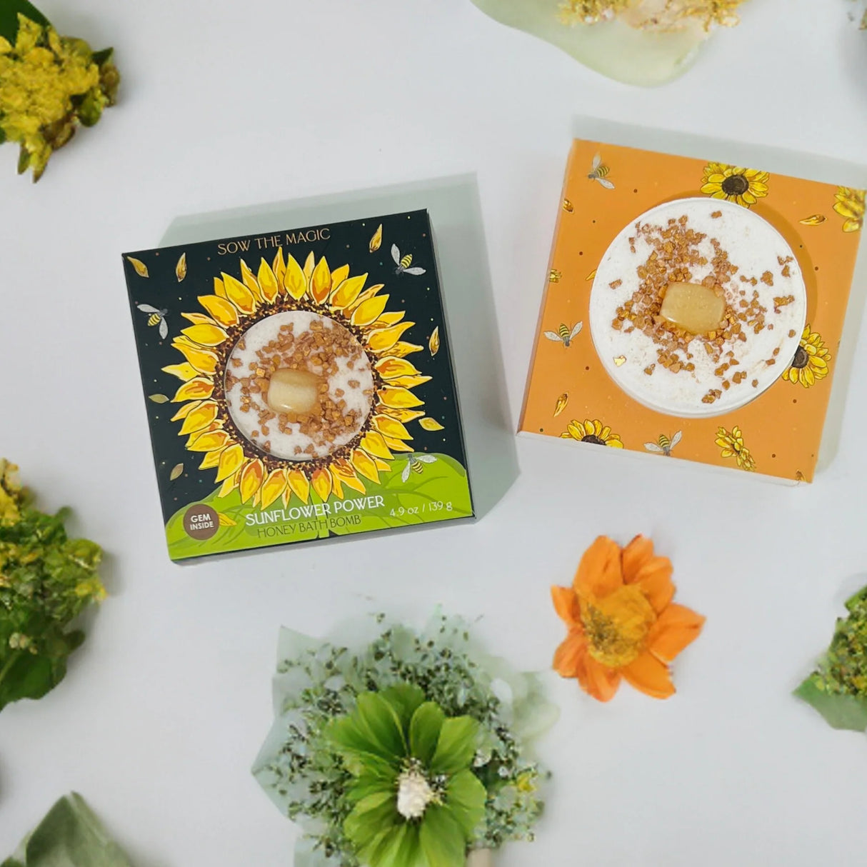 Sunflower-themed product packaging with sunflower bath bomb on a white surface.