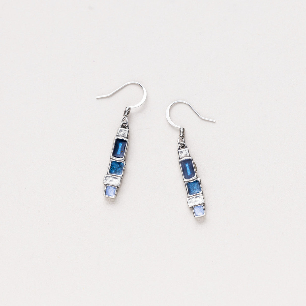 A pair of Danforth Pewter Stepping Stone earrings featuring asymmetrical blocks of vivid blue hues mixed with silver pewter, displayed on a white background