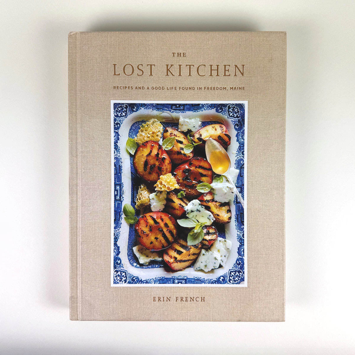 Cookbook titled 'The Lost Kitchen' by Erin French on a light background