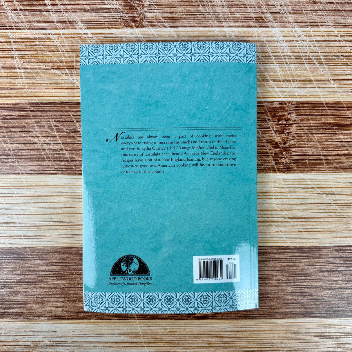 Blue book with text and a logo on a wooden surface