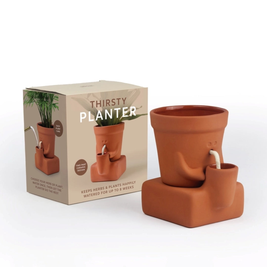 Terracotta planter with water reservoir and packaging labeled 'Thirsty Planter' on a white background.