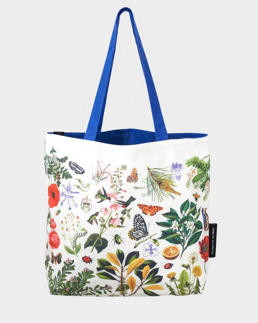 side one of the pollinator tote; a white tote bag with blue straps covered in vintage illustrations of hummingbirds, bees, butterflies, and the plants they pollinate