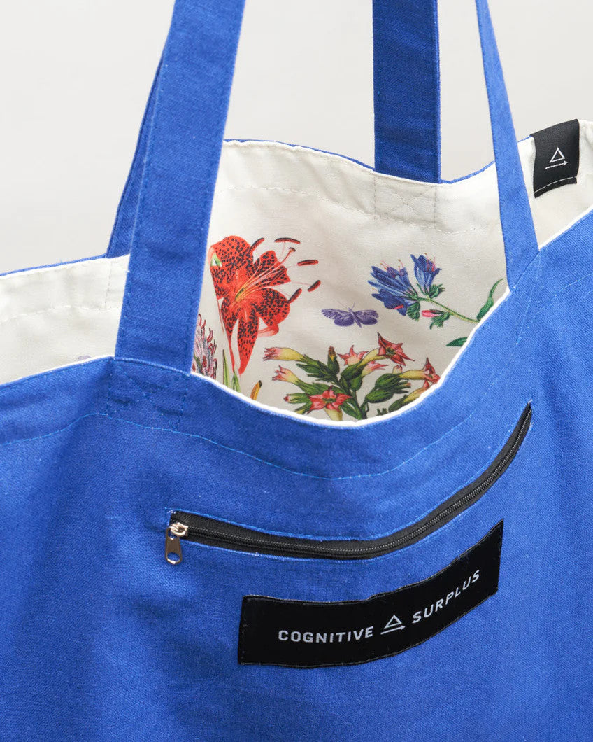 a close up of the tote near the handles showing the bag reversed so the pollinators print is on the inside of the tote and the outside is now a royal blue