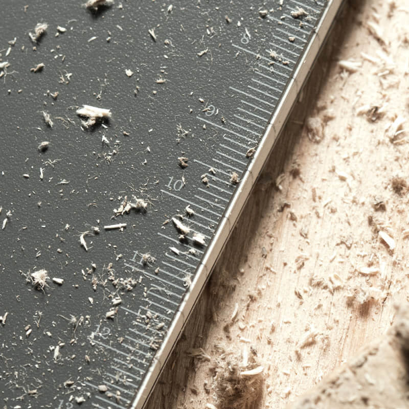 a close up of the ruler reference on the inside cover of the notebook on a wood surface and covered with sawdust